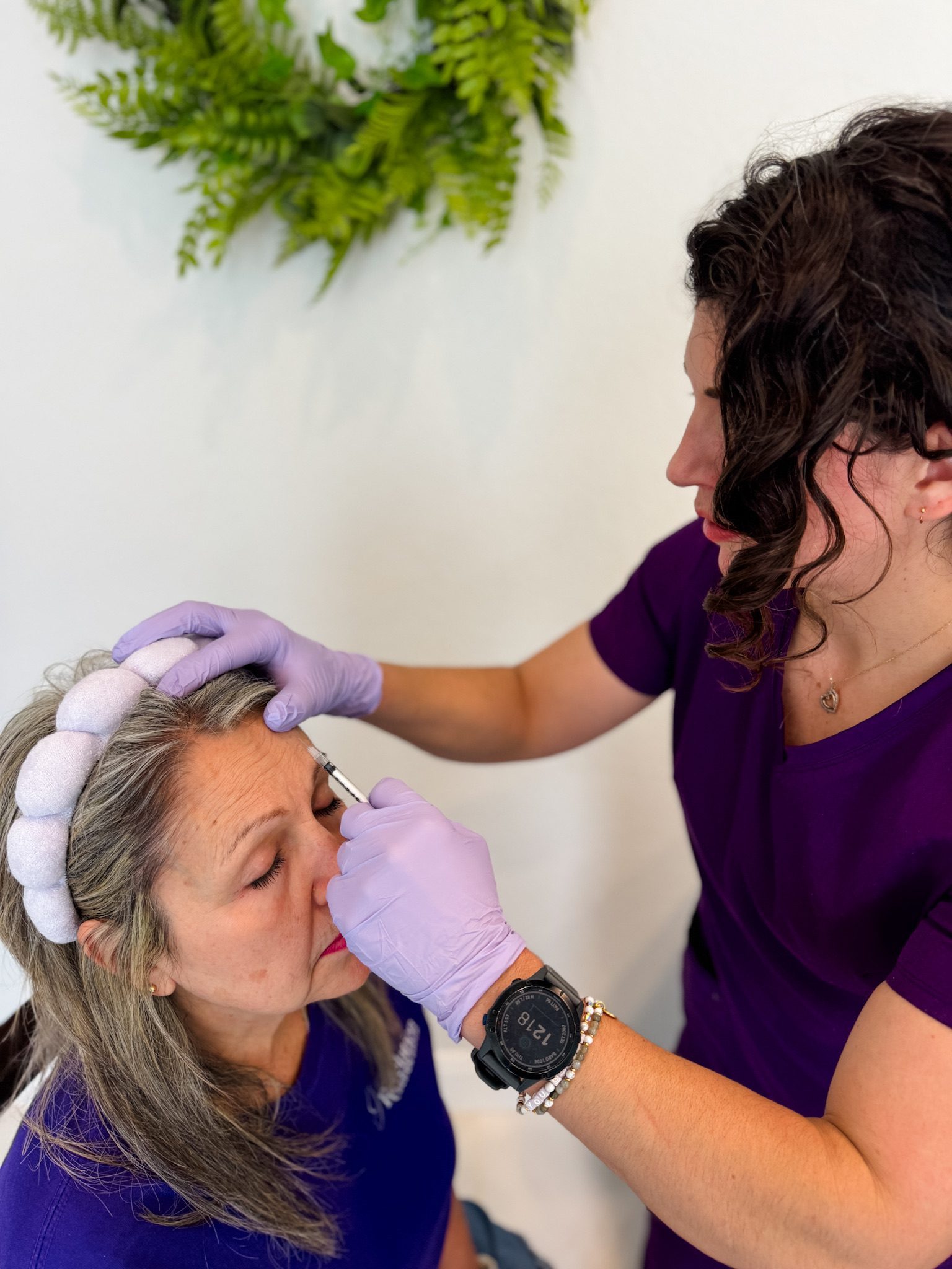 Woman receiving facial injection from healthcare professional.