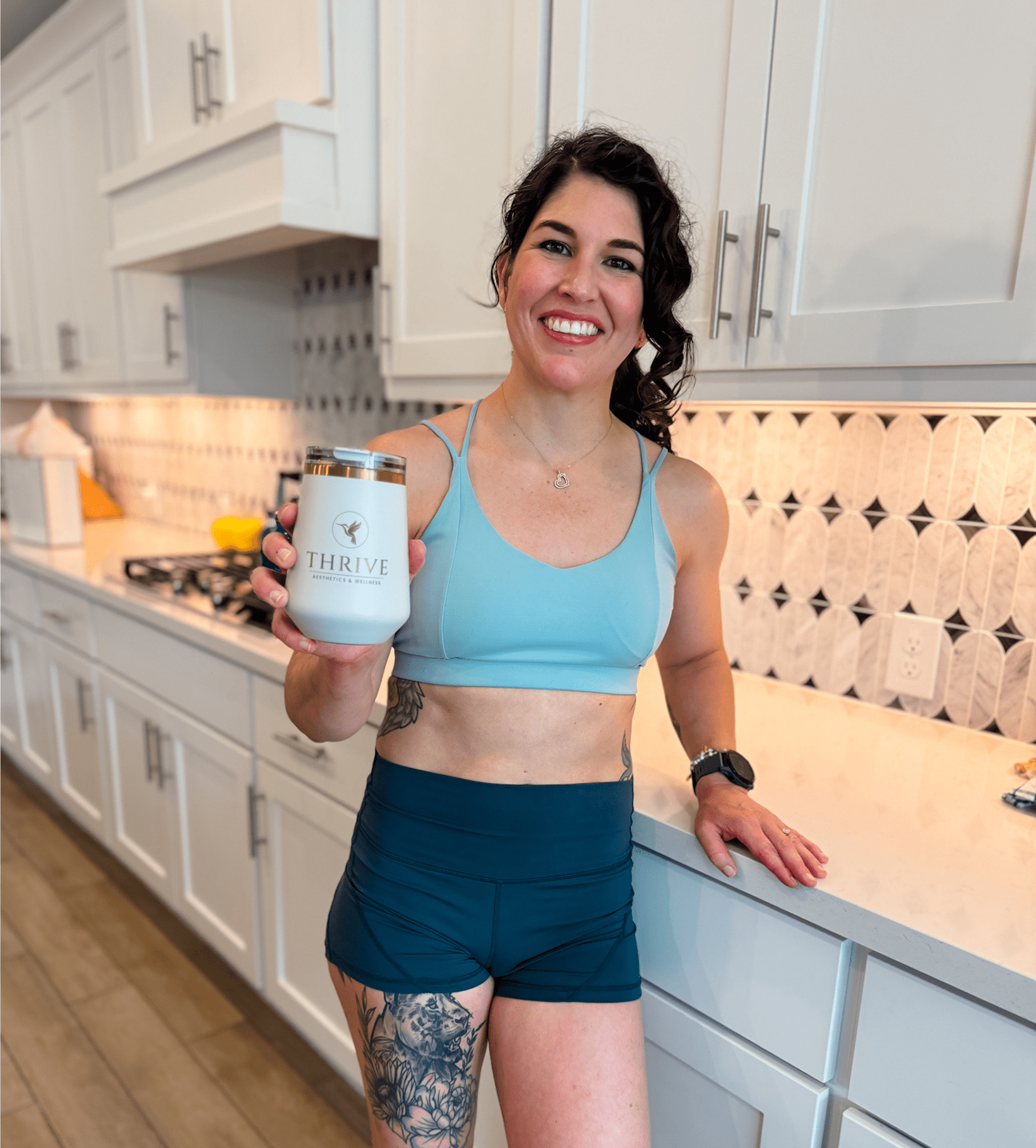 Woman holding a Thrive container, smiling indoors.